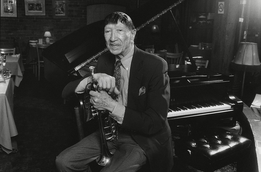 Paul J. Hoeffler, Doc Cheatham at the Montreal Bistro, Toronto, Ontario, 1994
Resin-coated gelatin silver print, 6 x 9 in. (15.2 x 22.9 cm)
Doc Cheatham (1905-1997), a masterful trumpeter, singer, and bandleader whose lifelong influence was Louis Armstrong. After touring widely his entire life, he settled in NY, playing a popular, regular Sunday gig at Sweet Basil in his final decade. Signed by the photographer. (A larger print is available, see [7389])
7394
$200